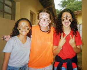 A young woman poses for a photo with two children